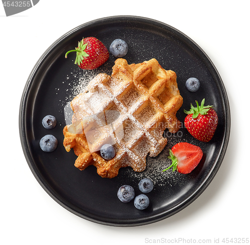 Image of freshly baked belgian waffle on black plate