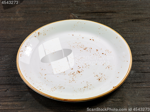 Image of empty plate on wooden table