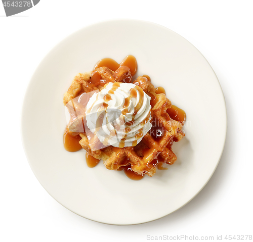 Image of belgian waffle decorated with cream and caramel sauce