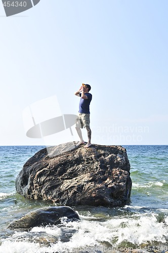 Image of Man stranded on a rock in ocean