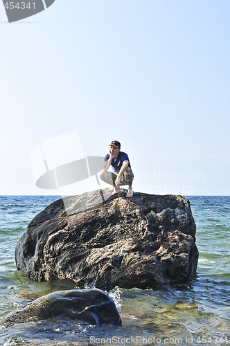 Image of Man stranded on a rock in ocean