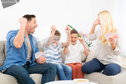 Image of Happy family playing card game on living room sofa at home and having fun together celebrating the game winner