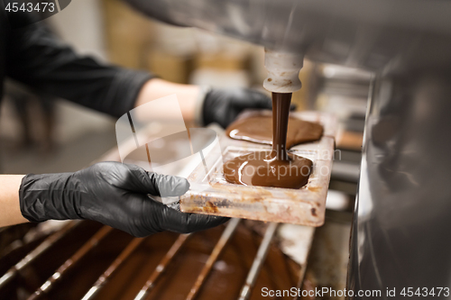 Image of confectioner makes chocolate candies at sweet-shop