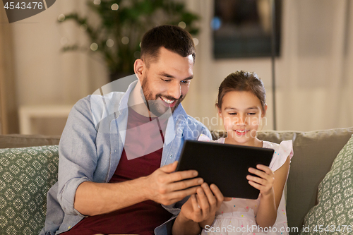 Image of father and daughter with tablet computer at home