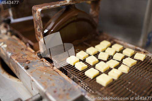 Image of candies processing by chocolate coating machine