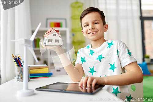 Image of boy with tablet, toy house and wind turbine