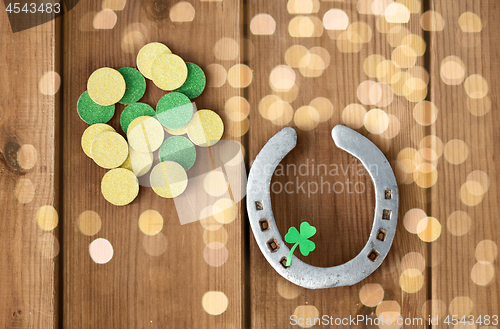 Image of horseshoe with shamrock on wooden background