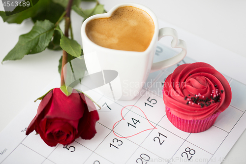 Image of close up of calendar, coffee, cupcake and red rose