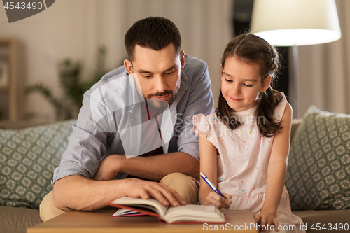 Image of father and daughter doing homework together