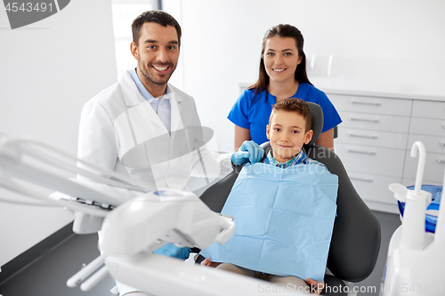 Image of dentists and kid patient at dental clinic