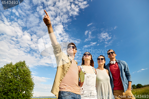Image of happy friends looking at something outdoors