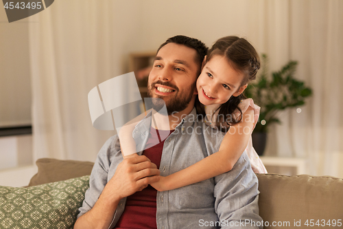 Image of happy father and little daughter hugging at home