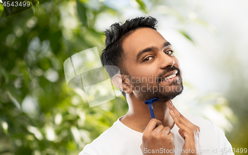 Image of indian man shaving beard with razor blade