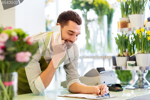 Image of florist man calling on smartphone at flower shop