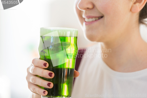 Image of close up of woman with green beer in glass