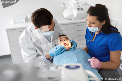 Image of dentist checking for kid teeth at dental clinic