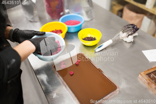 Image of confectioner makes chocolate dessert at sweet-shop