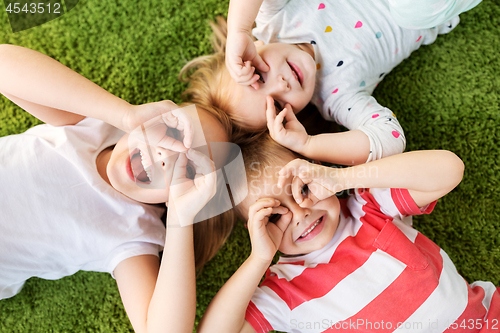 Image of happy little kids looking through finger glasses