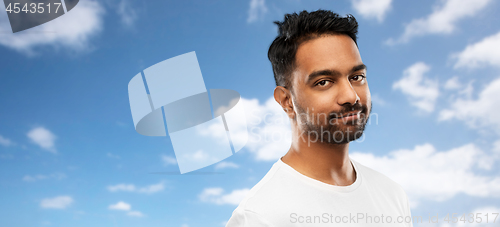Image of smiling young indian man over blue sky background