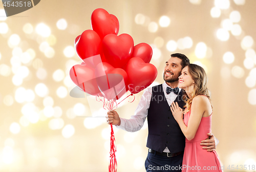 Image of happy couple with red heart shaped balloons