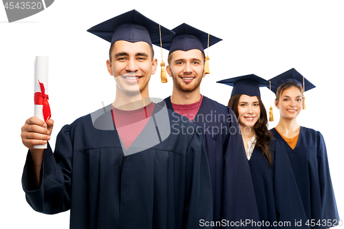 Image of graduates in mortar boards with diploma