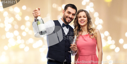 Image of happy couple with bottle of champagne and glasses