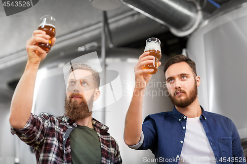 Image of men drinking and testing craft beer at brewery