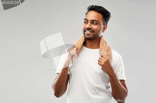 Image of smiling indian man with towel over grey background