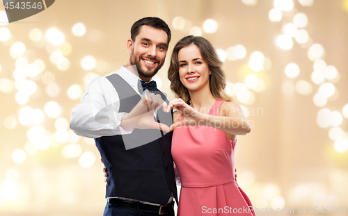 Image of happy couple making hand heart on valentines day