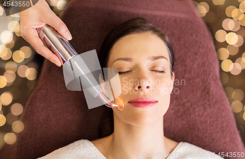 Image of woman having hydradermie facial treatment in spa