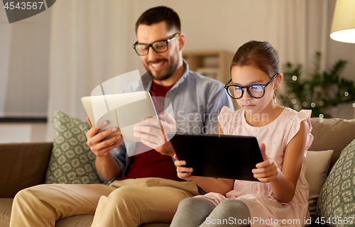 Image of father and daughter with tablet computers at home