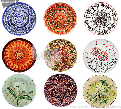 Image of Set of decorative ceramic dishes hand-painted with acrylic paints floral pattern isolated on white background
