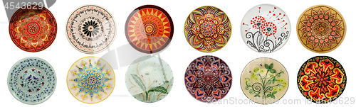 Image of Set of decorative ceramic dishes hand-painted with acrylic paints floral pattern isolated on white background
