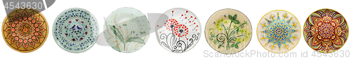 Image of Set of decorative ceramic dishes hand-painted with acrylic paints floral pattern isolated on white background