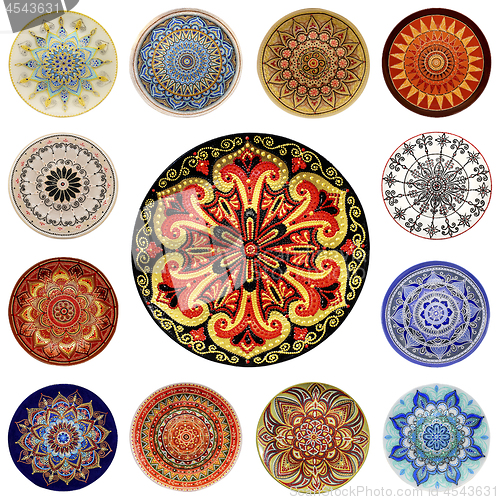 Image of Set of decorative ceramic dishes hand-painted with acrylic paints floral pattern isolated on white background