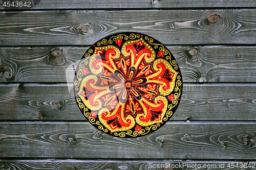 Image of Decorative ceramic plate, hand painted with acrylic paints on a wooden background. Closeup with place for text.