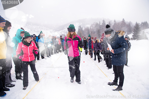 Image of group of young people having blindfolded games competition