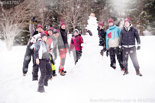 Image of group portait of young people posing with snowman