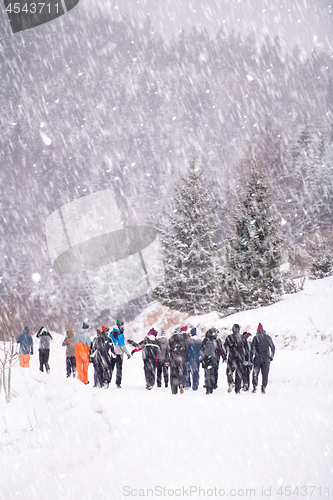 Image of group of young people walking through beautiful winter landscape