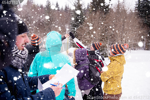 Image of young people measuring the height of finished snowman