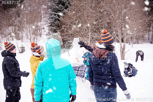 Image of group of young people making a snowman