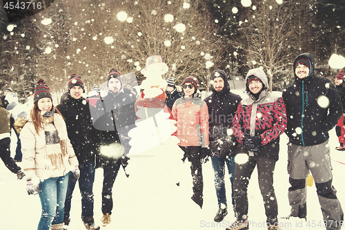 Image of group portait of young people posing with snowman