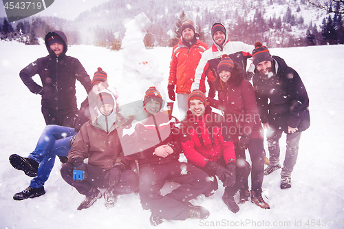 Image of group portait of young people posing with snowman