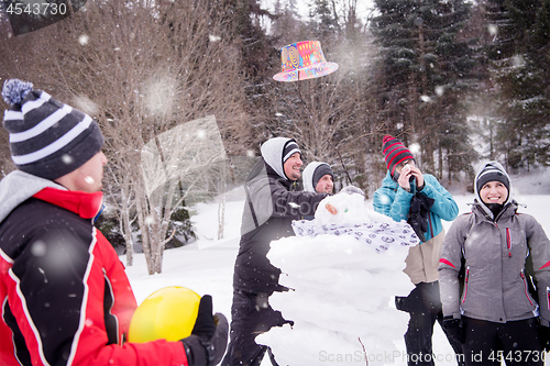 Image of group of young people making a snowman