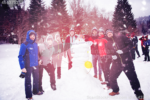 Image of group portait of young people posing with snowman