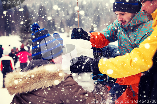 Image of group of young people making a snowman