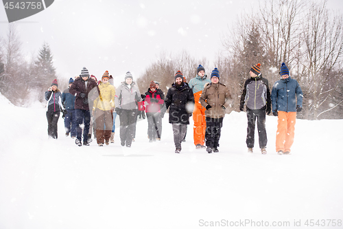 Image of group of young people walking through beautiful winter landscape