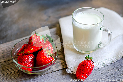 Image of Fresh strawberries and milkshake on a wooden on wooden boards