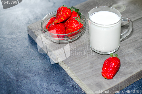 Image of Fresh strawberries and milkshake on a wooden on wooden boards