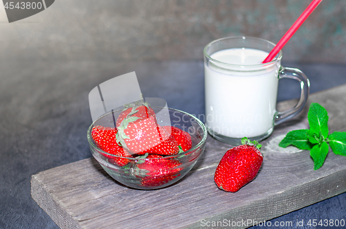 Image of Fresh strawberries and milkshake on a wooden on wooden boards